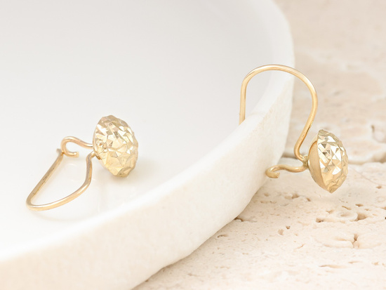 Złote kolczyki błyszczące na biglu