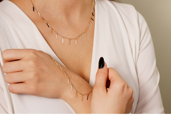 Złota bransoletka z zawieszkami wiszącymi blaszkami