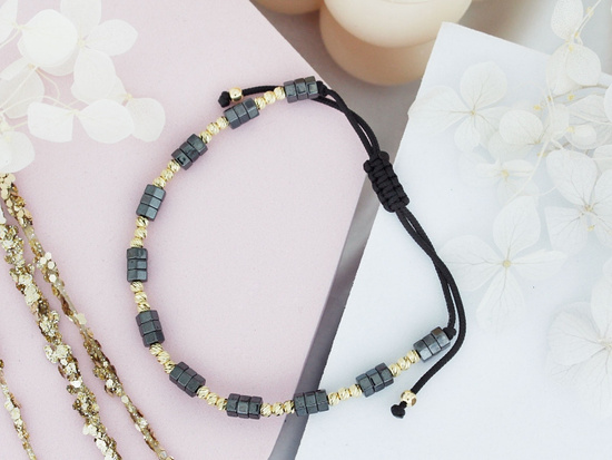 Bransoletka hematyty i złote kulki na czarnym sznurku