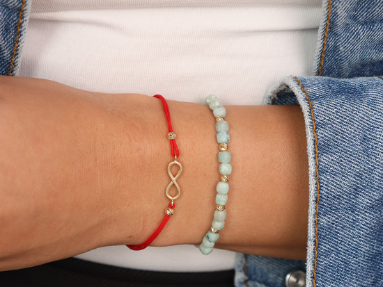 Bransoletka złote kulki i zielone kamienie na białym sznurku