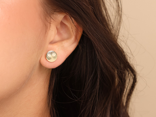 Kolczyki złote okrągłe błyszczące przy uchu pinezki