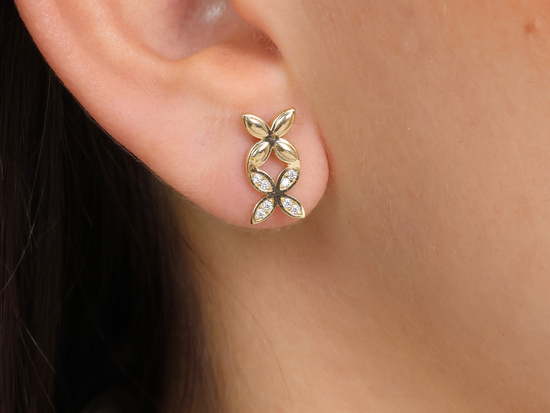 Złote kolczyki dwa kwiatki na sztyfcie przy uchu