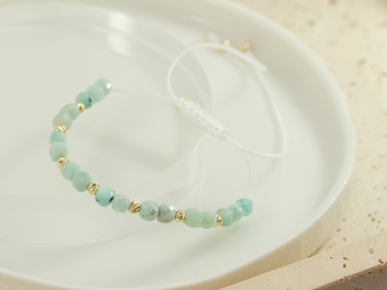 Bransoletka złote kulki i zielone kamienie na białym sznurku