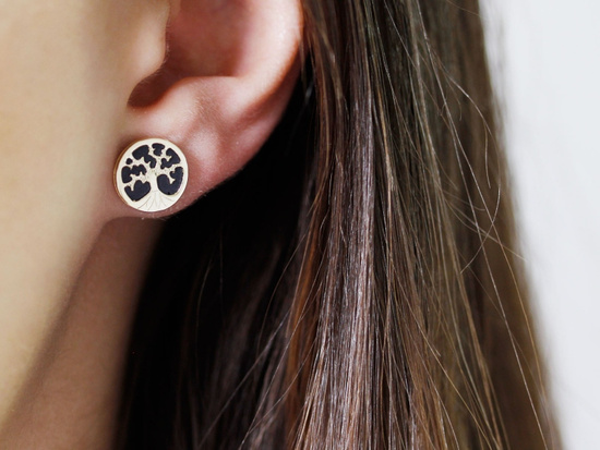 Złote kolczyki na sztyfcie z drzewkiem szczęścia na czarnym tle