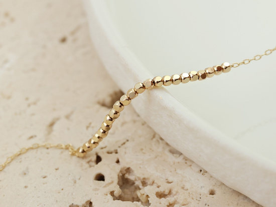 Delikatna złota bransoletka z małymi kostkami