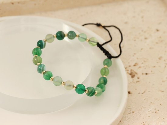 Bransoletka złote kulki i zielone kamienie na czarnym sznurku