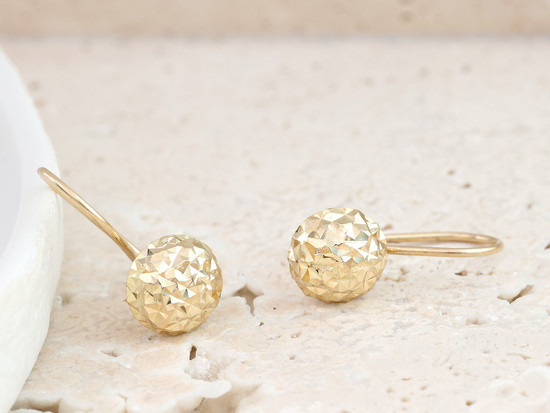 Złote kolczyki błyszczące na biglu