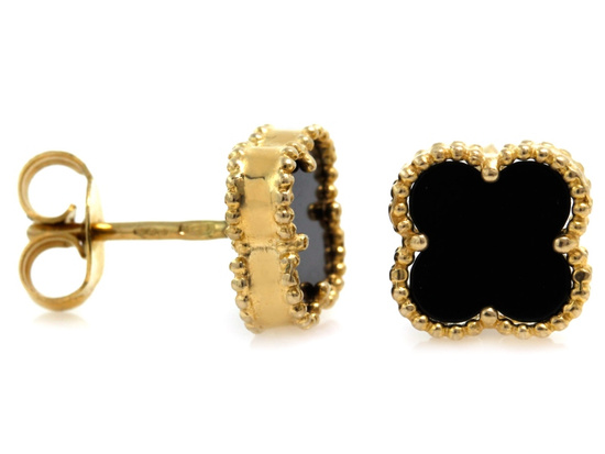 Złote kolczyki kwiatki z czarnym onyksem przy uchu