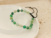 Bransoletka złote kulki i zielone kamienie na czarnym sznurku