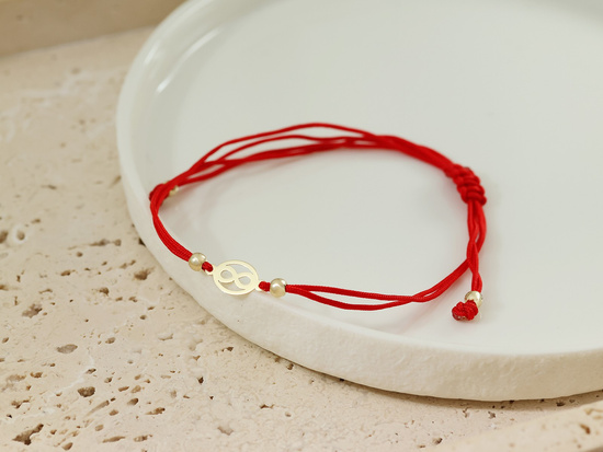 Bransoletka złota delikatna nieskończoność na czerwonym sznurku