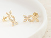 Złote kolczyki dwa kwiatki na sztyfcie przy uchu