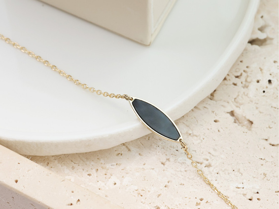 Złota bransoletka z czarnym owalnym kamieniem syntetycznym