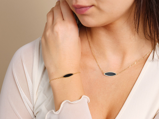 Złota bransoletka z czarnym owalnym kamieniem syntetycznym