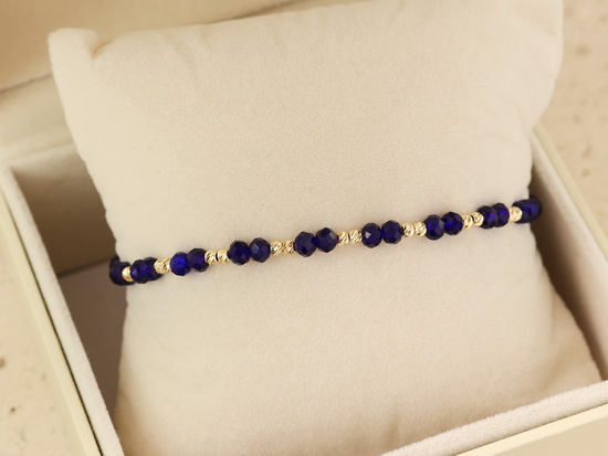 Bransoletka złota z kulkami na niebieskim sznurku