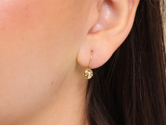 Złote kolczyki błyszczące na biglu