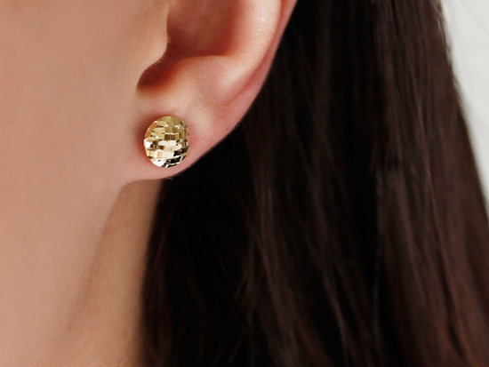 Kolczyki złote okrągłe błyszczące na sztyfcie pinezki przy uchu