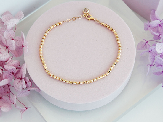 Bransoletka ze złotych błyszczących kulek