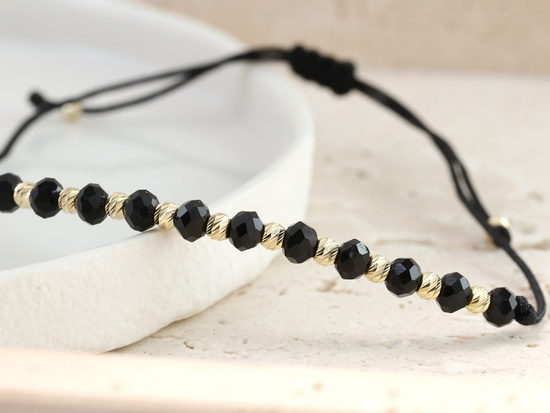 Bransoletki ze złotymi kulkami i czarnymi kamieniami na sznurku