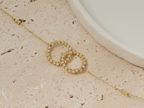 Złota bransoletka dwie obrączki i kuleczki