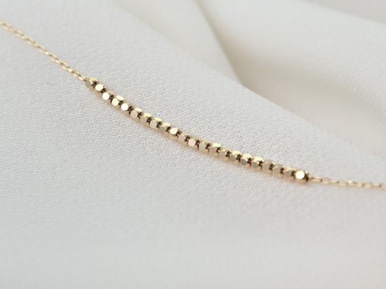 Delikatna złota bransoletka z małymi kostkami