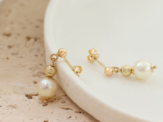 Delikatne złote kolczyki wiszące z perłą i kulką