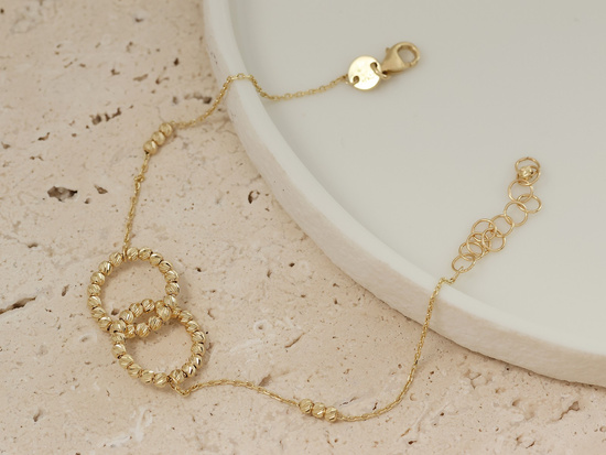 Złota bransoletka dwie obrączki i kuleczki