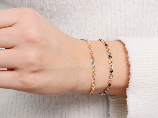 Złota bransoletka z nieskończoności z czarnymi kamieniami