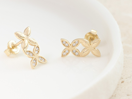 Złote kolczyki dwa kwiatki na sztyfcie przy uchu
