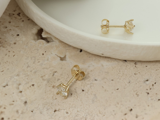 Kolczyki złote z cyrkonią na sztyfcie przy uchu